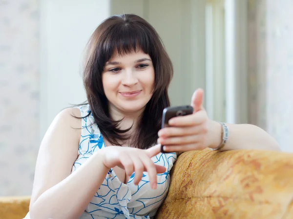 Adult woman sends SMS by mobile — Stock Photo, Image