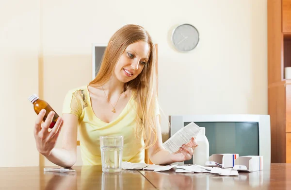 Serious woman reading manual of medications — Stock Photo, Image