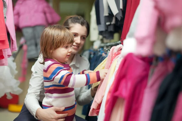 Donna e bambino sceglie di indossare al negozio — Foto Stock