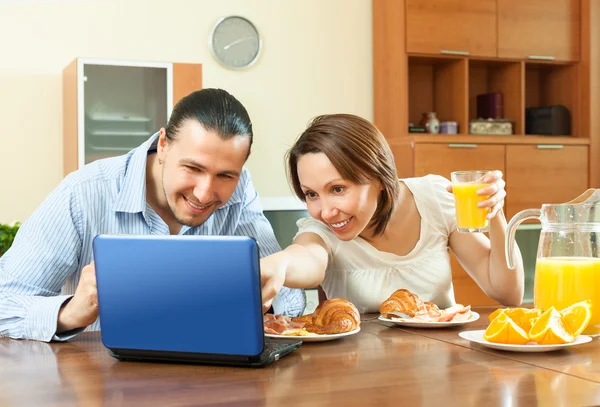 Casal olhando e-mail durante o café da manhã — Fotografia de Stock