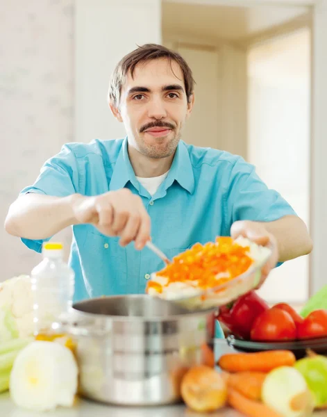 Homem sorridente cozinha almoço — Fotografia de Stock