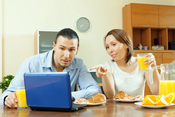 Casal olhando e-mail durante o café da manhã — Fotografia de Stock