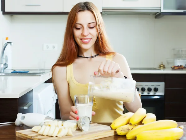 Žena nalil mléčný koktejl s banány — Stock fotografie