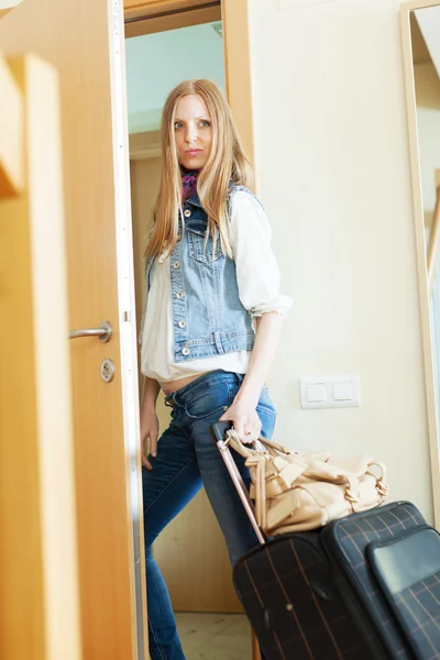 Mujer triste con el equipaje saliendo de casa —  Fotos de Stock