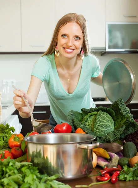 Positive femme au foyer cuisine légumes frais — Photo