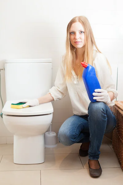 Long-haired woman cleaning toilet bowl with sponge — Stock Photo, Image