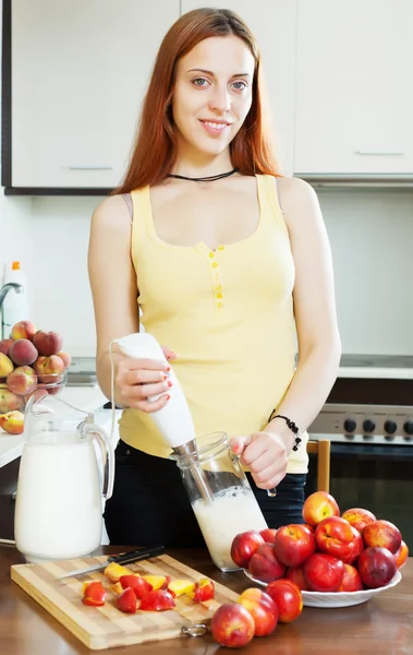 Vrouw koken dranken met blender van nectarines — Stockfoto