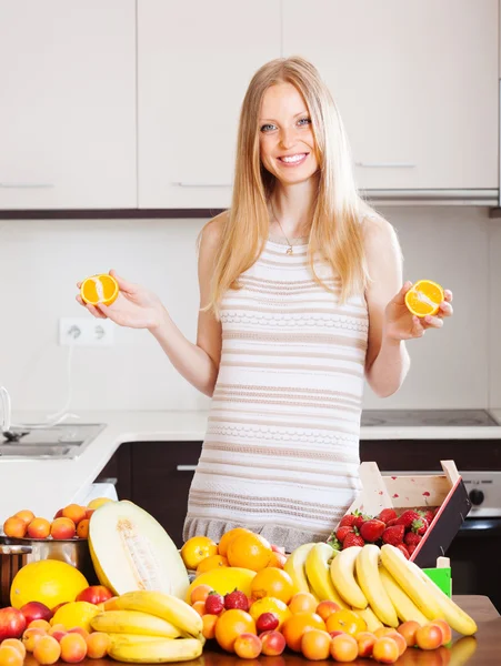 Позитивная женщина с апельсинами и другими фруктами — стоковое фото