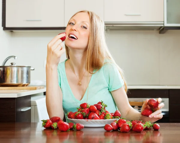 Mujer de pelo largo comiendo fresa en casa —  Fotos de Stock