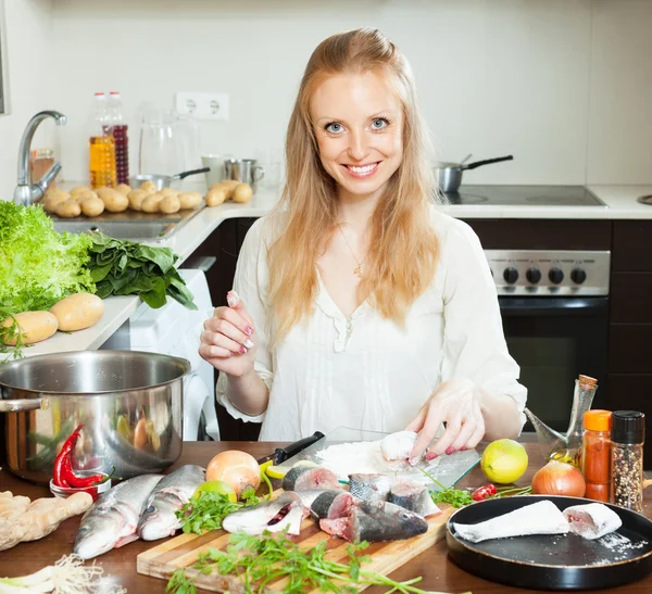 Happy housewife cooking saltwater fish in flour — Stock Photo, Image