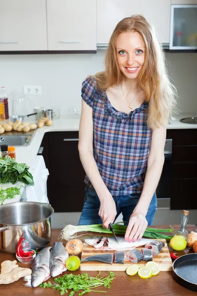 Donna bionda affettare pesce crudo — Foto Stock