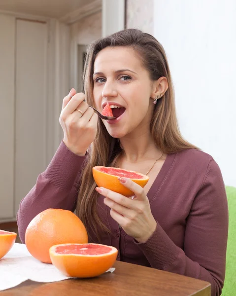 Tjej äter grapefrukt med sked — Stockfoto
