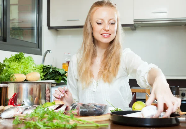 Positive woman cooking fish in flour — Stock Photo, Image