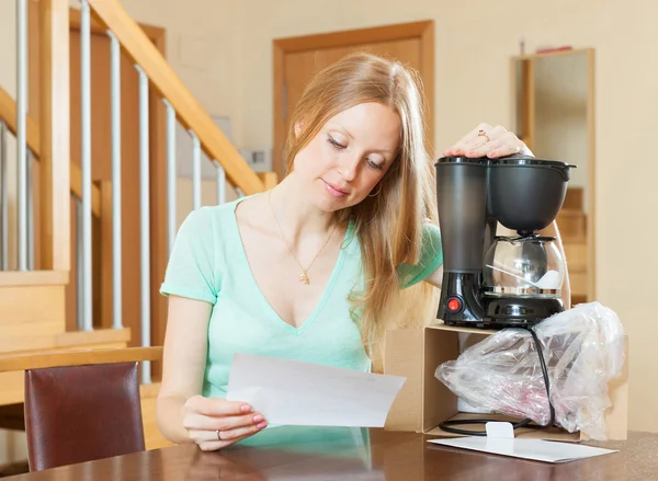 Jovem mulher com nova máquina de café em casa — Fotografia de Stock