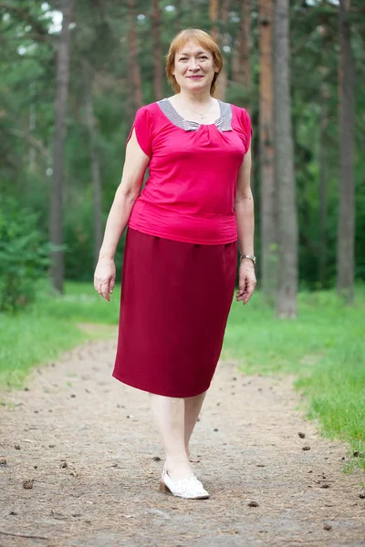 Женщина гуляет по сосновому лесу — стоковое фото