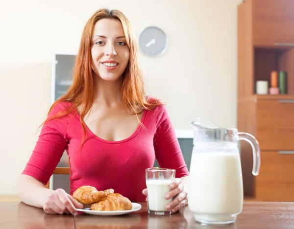 Mujer joven sonriente desayunando con leche por la mañana —  Fotos de Stock