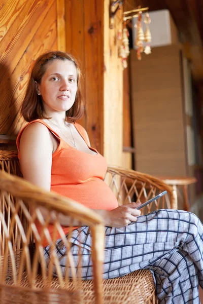 Беременная женщина читает электронную книгу — стоковое фото