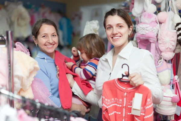 Duas mulheres e criança na loja de roupas — Fotografia de Stock