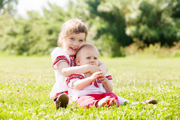 Niños felices en ropa popular rusa en el prado —  Fotos de Stock