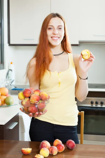 Kaunis tyttö keltaisessa persikoiden kanssa — kuvapankkivalokuva