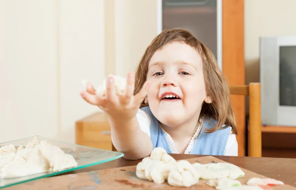 Baby girl sculpting from clay or dough in home — Stock Photo, Image