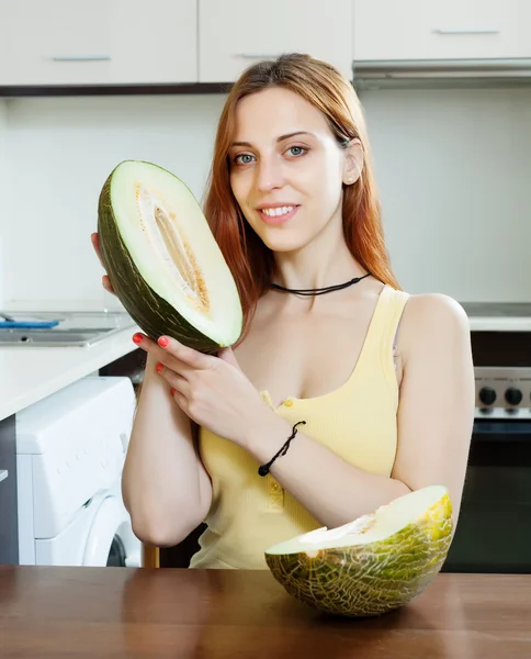 Woman holding melon in kitchen — Stock Photo, Image