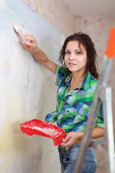 Frau bemalt Wand mit Pinsel — Stockfoto