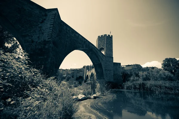 Medieval stone bridge over river. Imitation of old image — Stock Photo, Image
