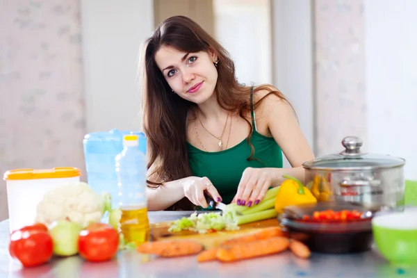 Mujer cortando verduras en su cocina — Foto de Stock