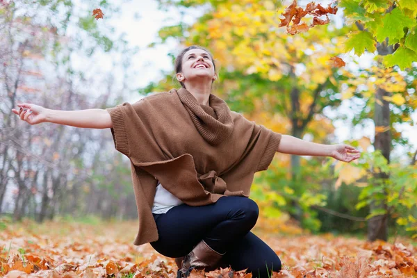 Happy girl throws maple leaves — Stock Photo, Image