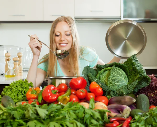 长头发的家庭主妇用新鲜的蔬菜烹饪 — 图库照片