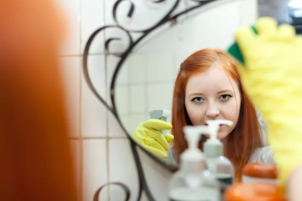 Teen girl cleans mirror with sponge — Stock Photo, Image