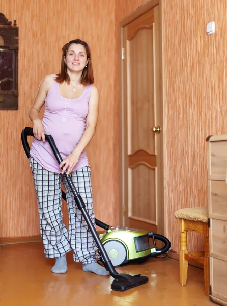 Mulher grávida limpando sua sala de estar — Fotografia de Stock