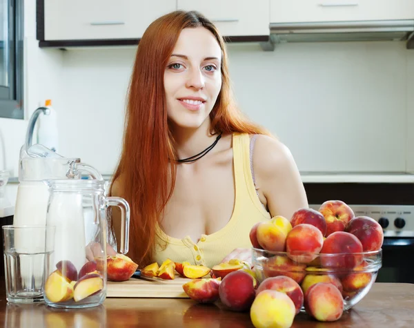 Nainen kokkaamassa persikoiden kanssa — kuvapankkivalokuva