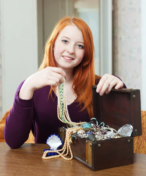 Girl looks jewelry in treasure chest — Stock Photo, Image