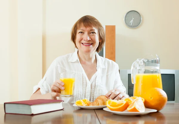 Woman having breakfast with book — Stock Photo, Image
