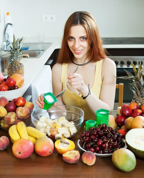 Nainen ruoanlaitto hedelmäsalaattia — kuvapankkivalokuva