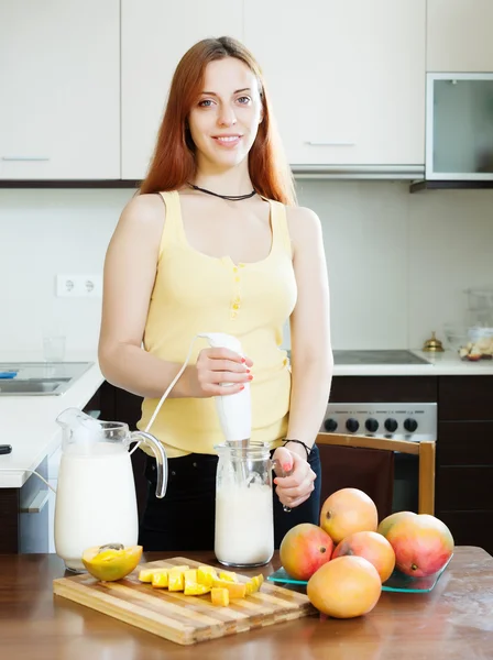 Woman making milk shake with mango — Stock Photo, Image