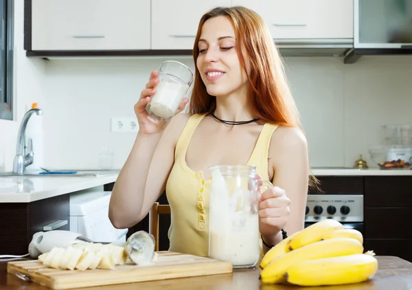 Positive woman drinking milkshake with bananas — Stock Photo, Image