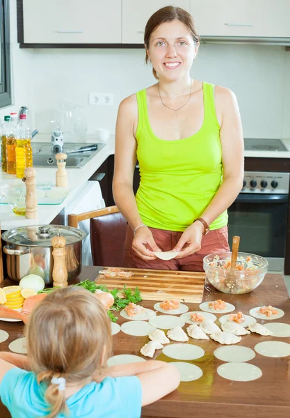 Donna con un bambino che fa gnocchi di pesce salmone più fresco — Foto Stock