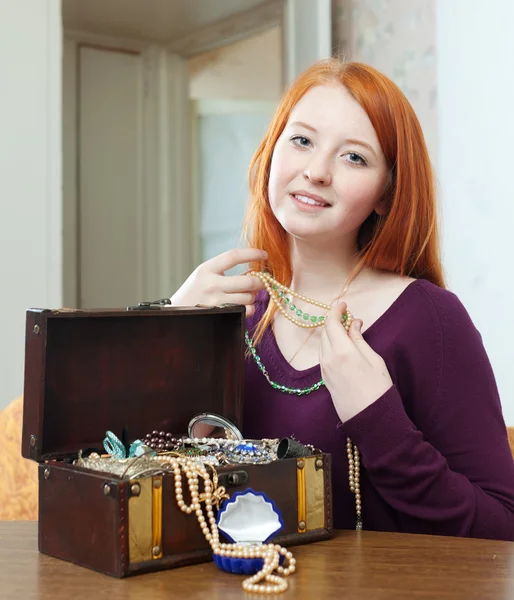 Rödhåriga tjejen ser smycken — Stockfoto