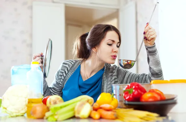 Young woman tests food — Stock Image Young woman tests food Royalty Free Stock Images