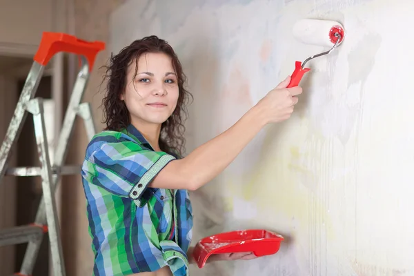 Femme peint mur avec rouleau — Photo