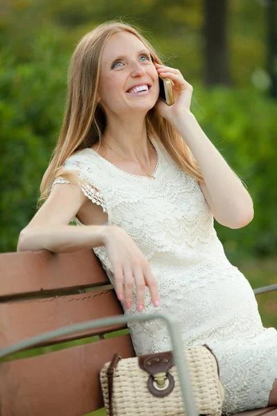 Pregnant woman talking by phone — Stock Photo, Image