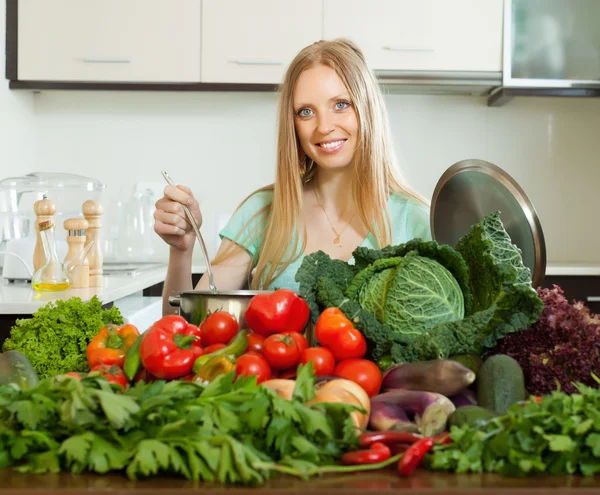 Femme heureuse cuisine avec tas de légumes crus — Photo