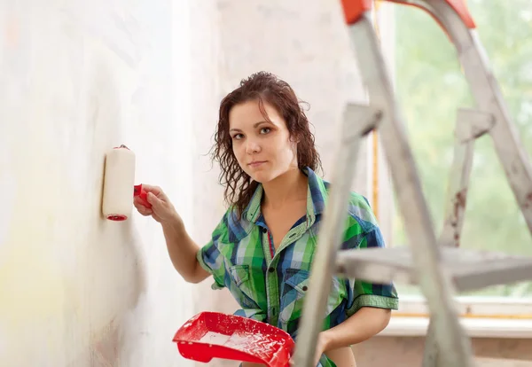 Mujer pinta pared con rodillo — Foto de Stock