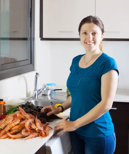 Jeune femme au foyer cuisine fruits de mer — Photo