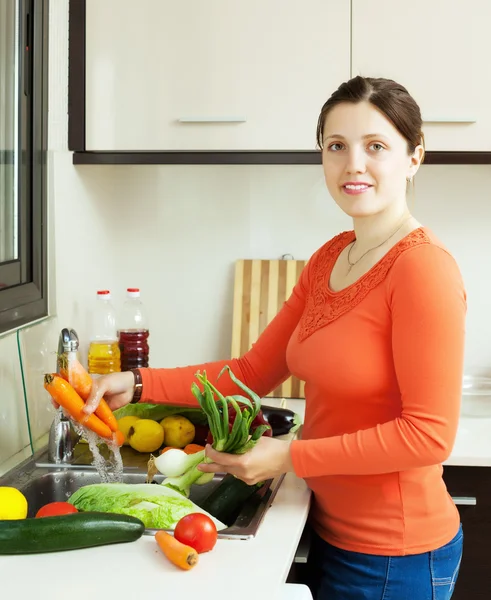 Vrouw wassen verse groenten in gootsteen — Stockfoto