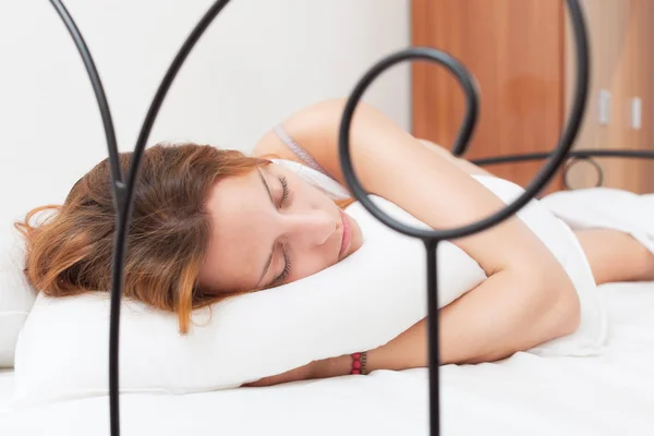 Zrzavý žena spící na bílém polštáři v posteli — Stock fotografie