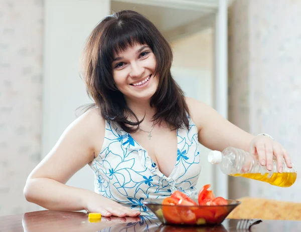 Femme verser de l'huile aux légumes à la maison — Photo